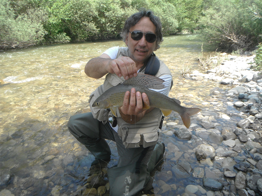 man holding grayling in italy